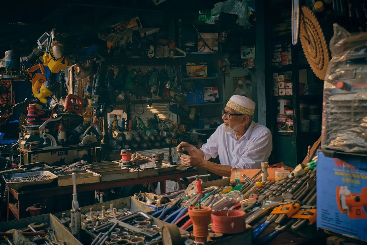 Dueño de un comercio de materiales eléctricos atendiendo en el mostrador